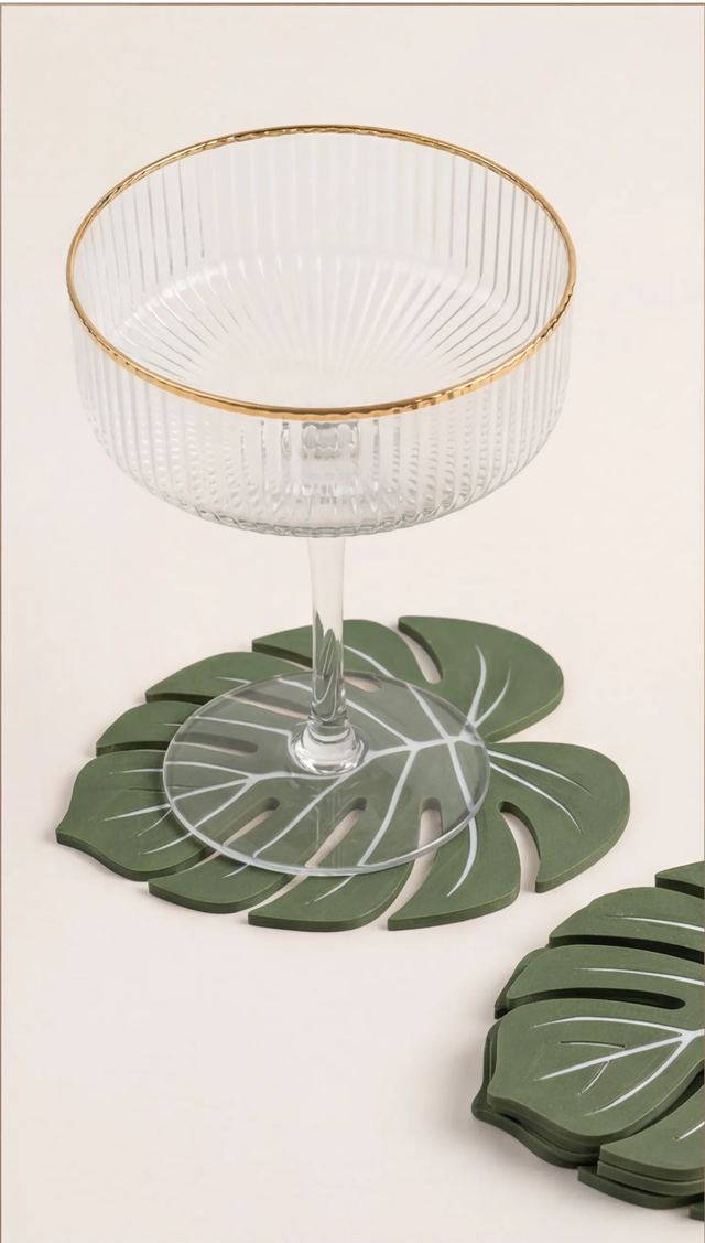 Taça com borda dourada apoiada sobre uma folha verde